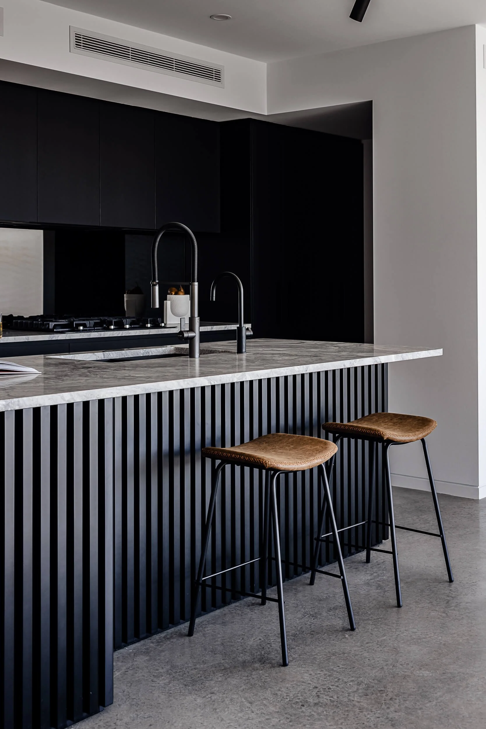 Premium architectural photography and film documenting true materiality and craftsmanship—highlighting slatted island joinery, marble tops, and leather soft furnishings—for Master Builders and designers in Regional NSW.