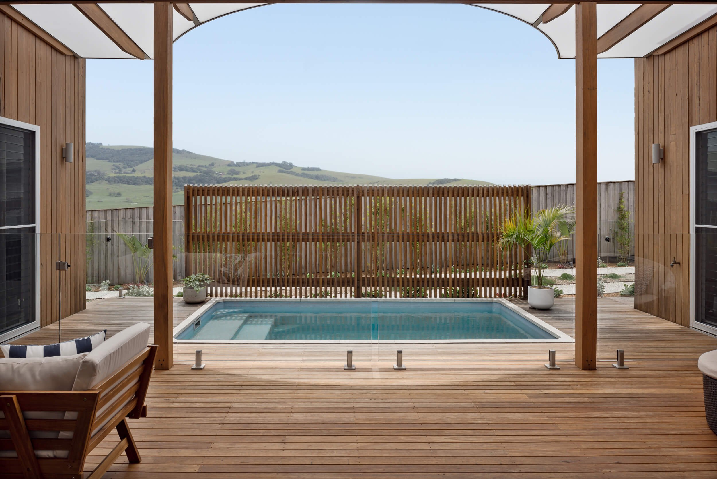 Coastal plunge pool, timber deck, and rolling hinterland views at Pacific 5. Premium architectural photography and film documenting true materiality and craftsmanship for Master Builders, architects and designers in Regional NSW.