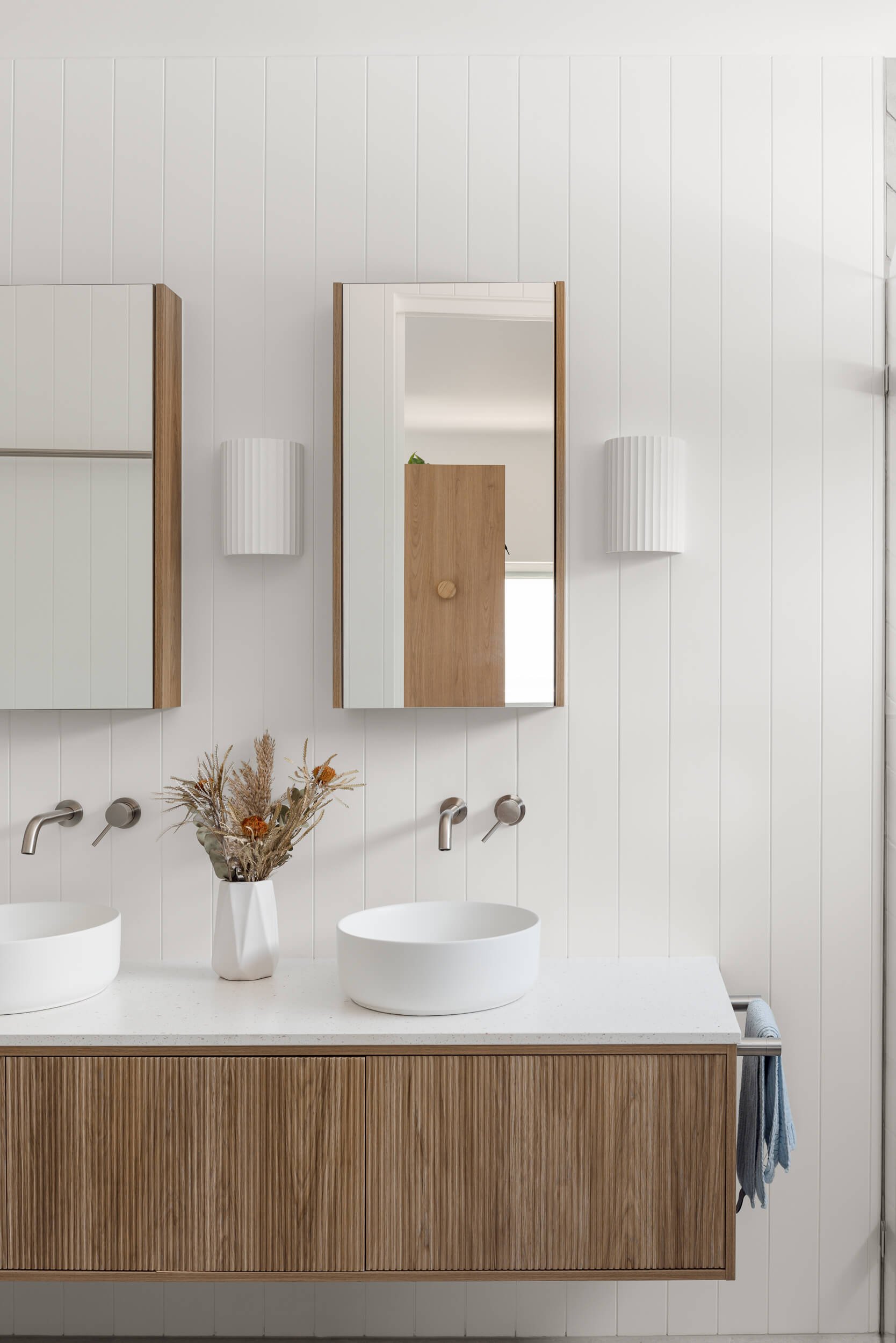 Coastal bathroom interior featuring a ribbed timber vanity and dual vessel sinks at Pacific 5. Premium architectural photography and film documenting true materiality and craftsmanship for Master Builders, architects and designers in Regional NSW.