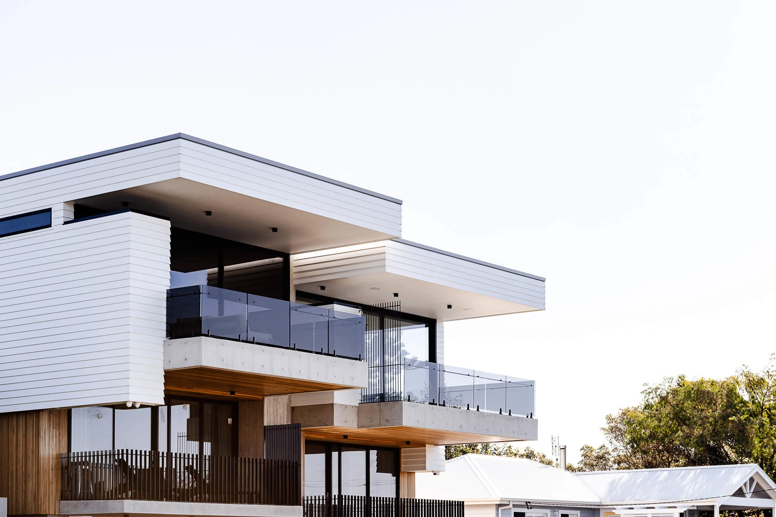 Premium architectural photography and film documenting true materiality and craftsmanship—highlighting cantilevered off-form concrete, timber soffits, and modern linear cladding—for Master Builders and designers in Regional NSW