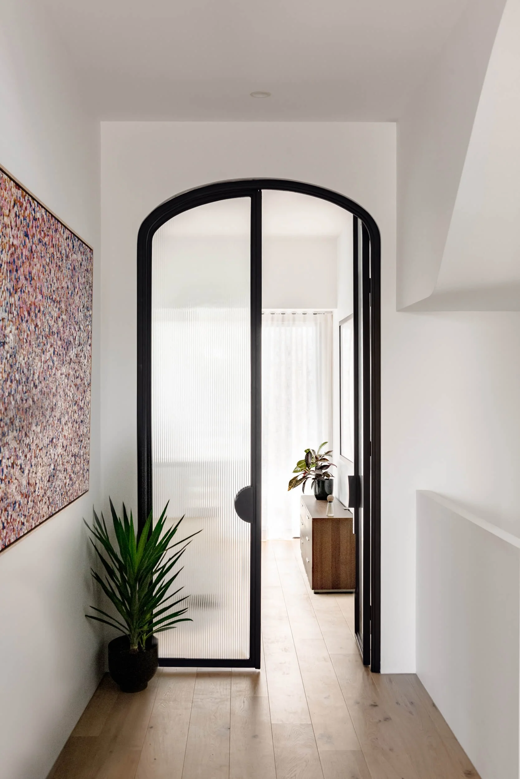 Custom arched steel-framed reeded glass doors open framing interior corridor at Stonemasons House in Vaucluse, NSW Architecture photography & cinema by Light & Lines