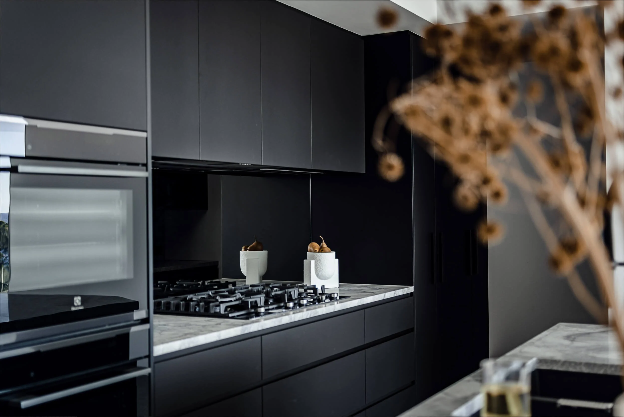 Premium architectural photography and film documenting true materiality and craftsmanship—highlighting dark matte cabinetry, marble benchtops, and mirror splashbacks—for Master Builders and designers in Regional NSW.