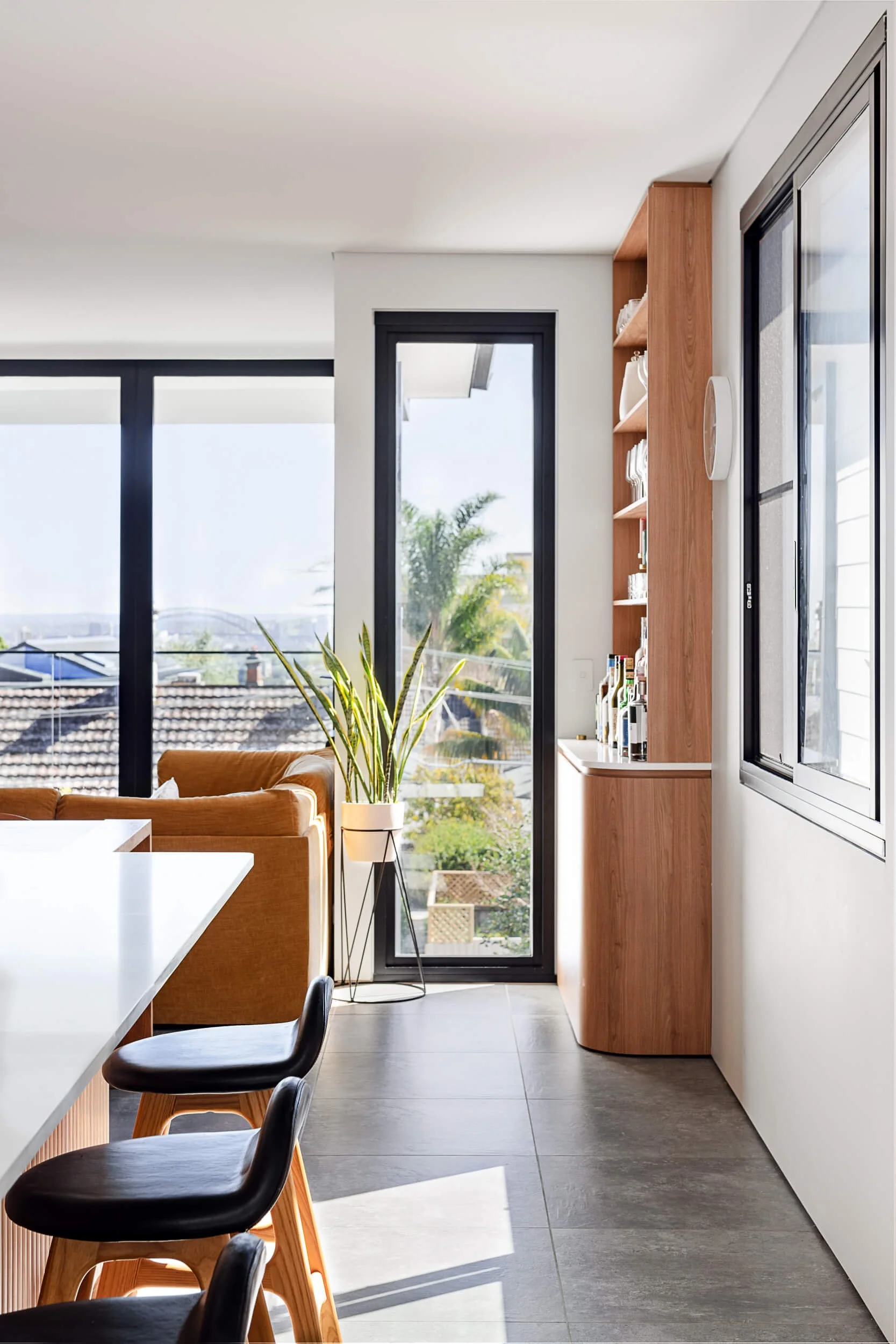 Floating open-tread timber staircase featuring a wooden handrail, indoor planter, and vertical slot window at Bondi Heights in Sydney, NSW