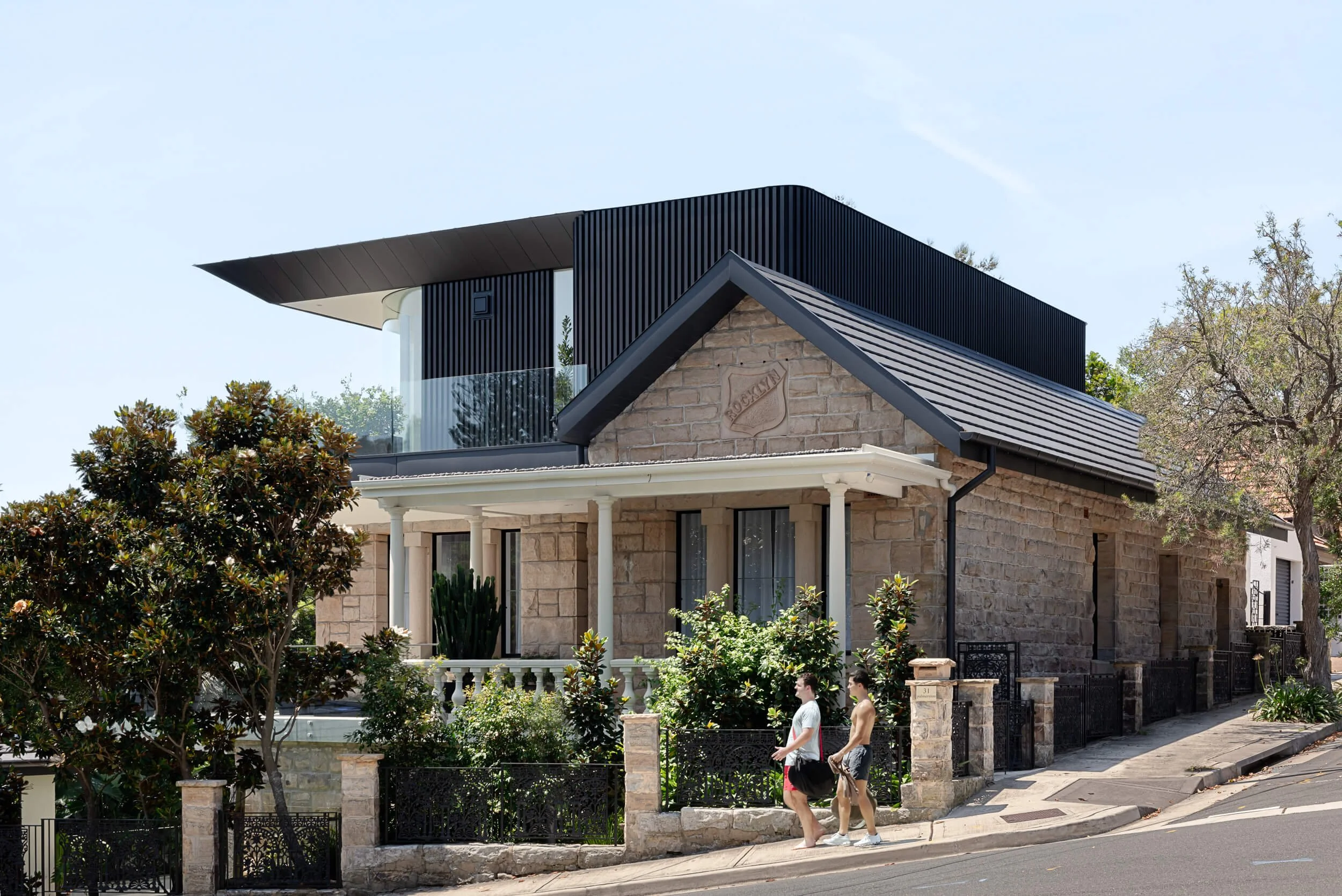 Palmerston residence in Vaucluse NSW, featuring a restored heritage sandstone facade, integrated with a modern black timber second-story addition.  Designed by Spicer Architecture and built by Bledisloe Group with architectural photography and cinema
