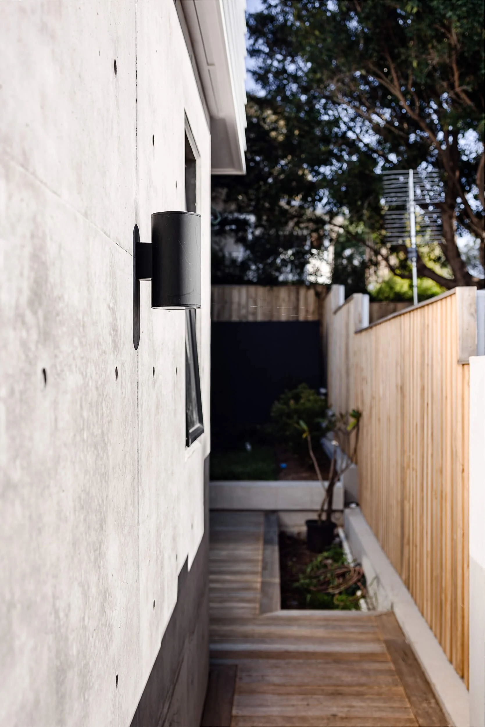 Timber staircase and custom paneled door with timber handle at Pacific 5. Premium architectural photography and film documenting true materiality and craftsmanship for Master Builders, architects and designers in Regional NSW.