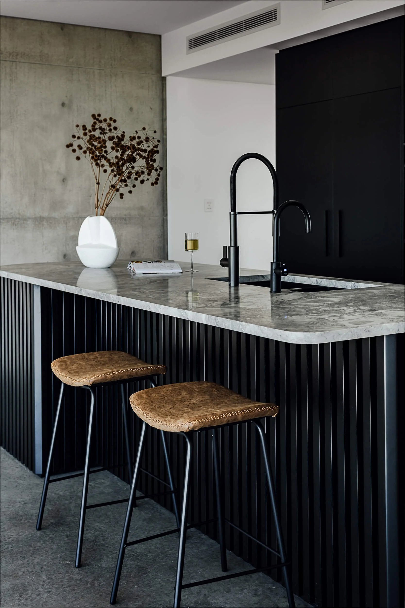 Premium architectural photography and film documenting true materiality and craftsmanship—highlighting raw off-form concrete, matte black tapware, and custom kitchen joinery—for Master Builders and designers in Regional NSW.