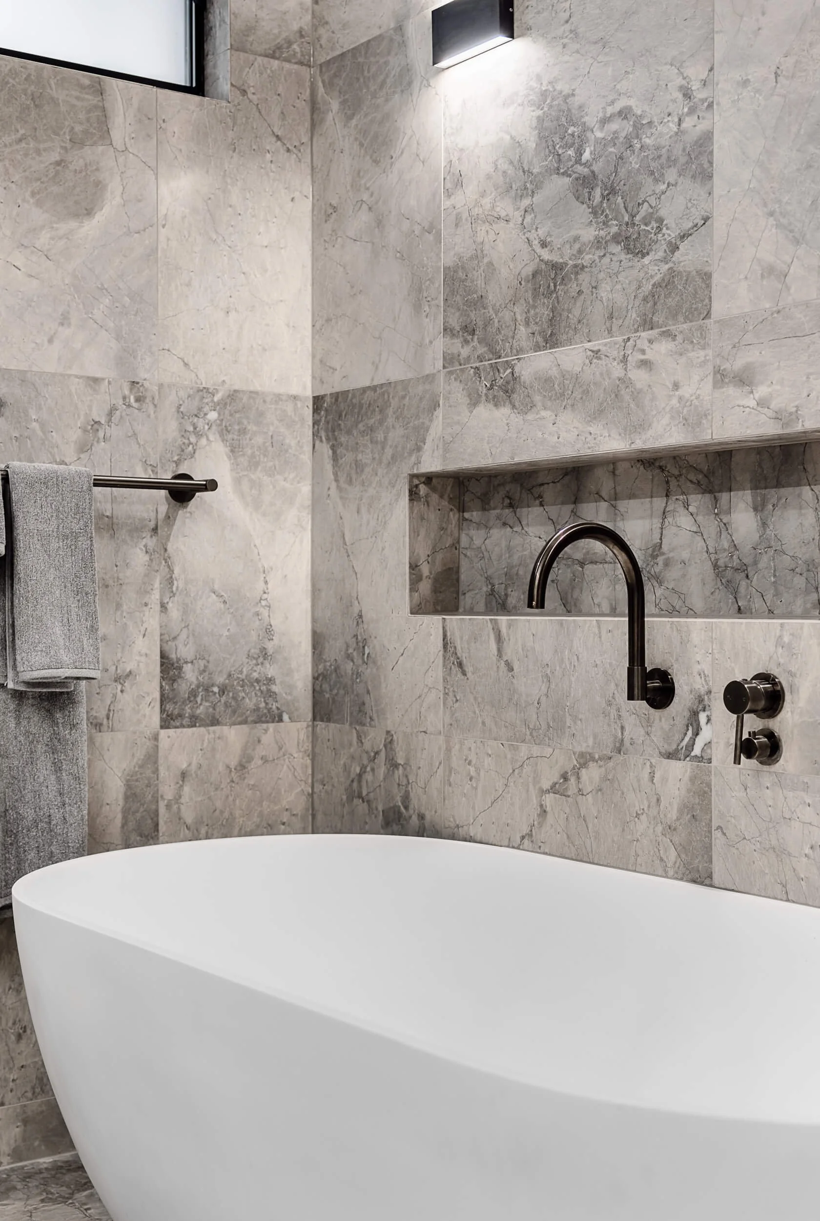 Premium architectural photography and film documenting true materiality and craftsmanship—highlighting freestanding bath design, matte black wall tapware, and custom stone niches—for Master Builders and designers in Regional NSW.