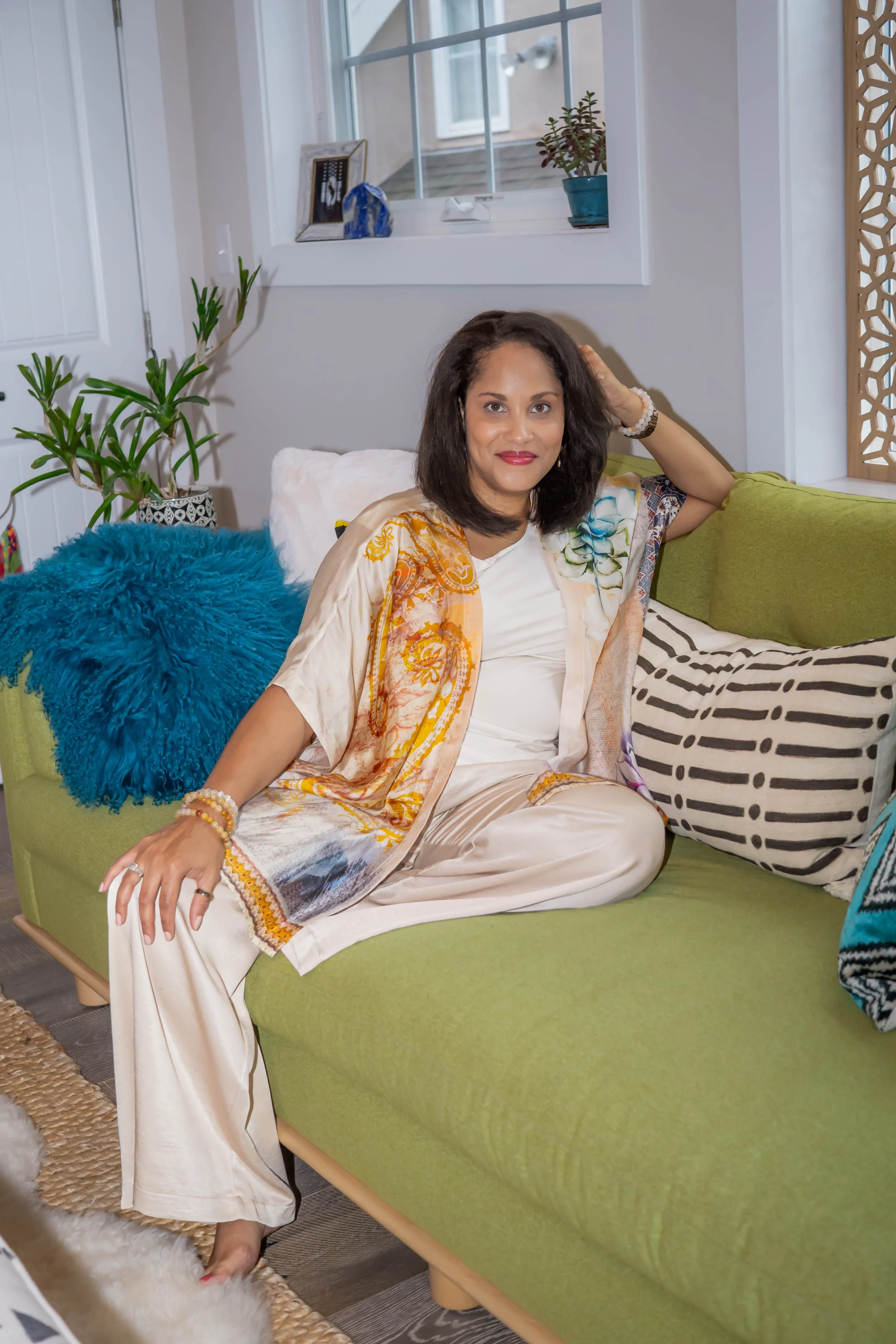 woman sitting on green couch with pillows