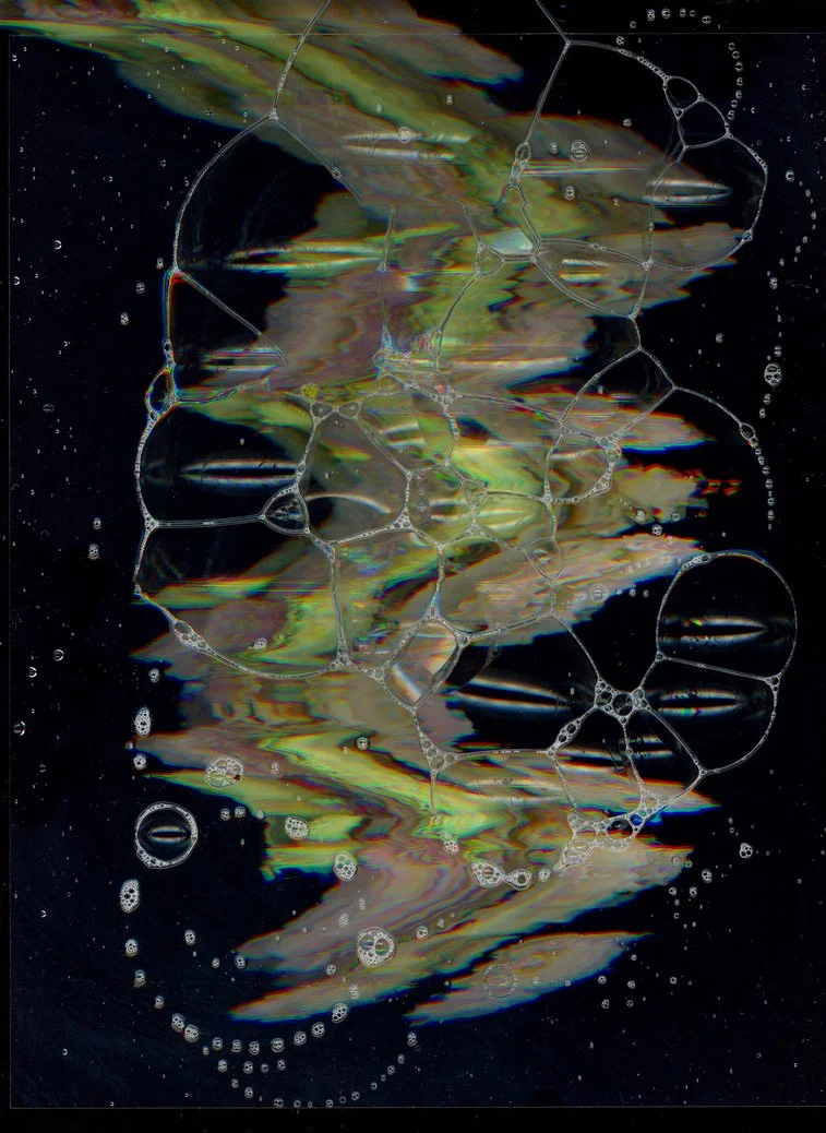 Soap bubbles on a dark background with iridescent colors and soap film patterns. Created with scanography