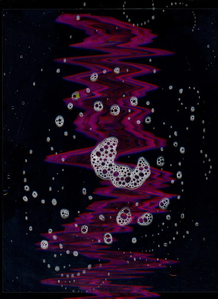Abstract digital art featuring a dark background with colorful, swirling red and purple patterns and numerous soap bubbles. Created with scanography