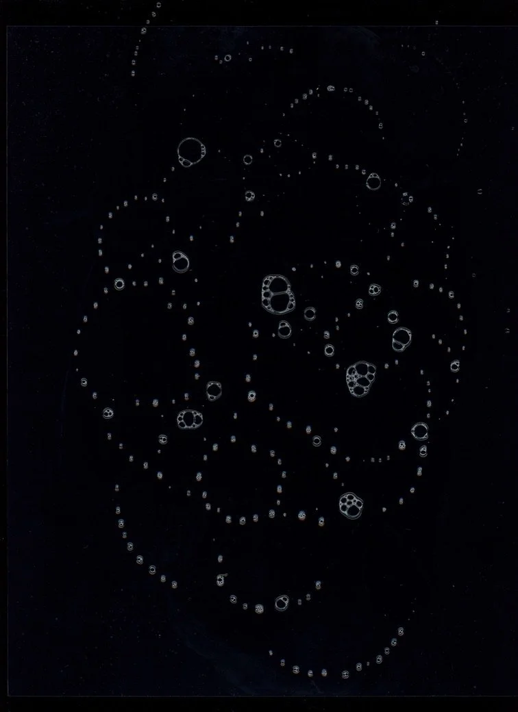 Close-up of coffee bubbles on the surface of a dark liquid. Created with scanography