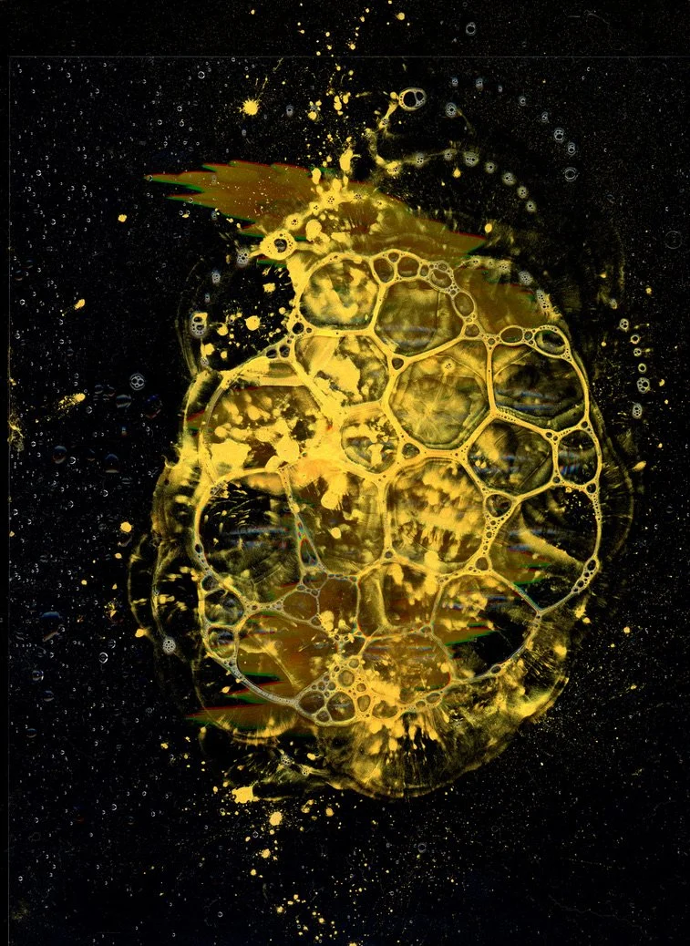 Abstract close-up of a pineapple under a microscope showing the fruit's cells and bubbles, with a black background and golden yellow hues. Created with scanography