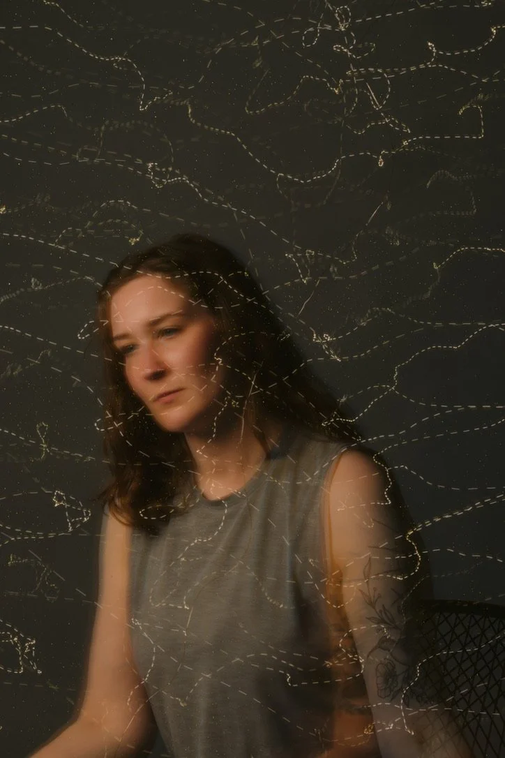 Artistic portrait of a woman with overlay of light patterns.
