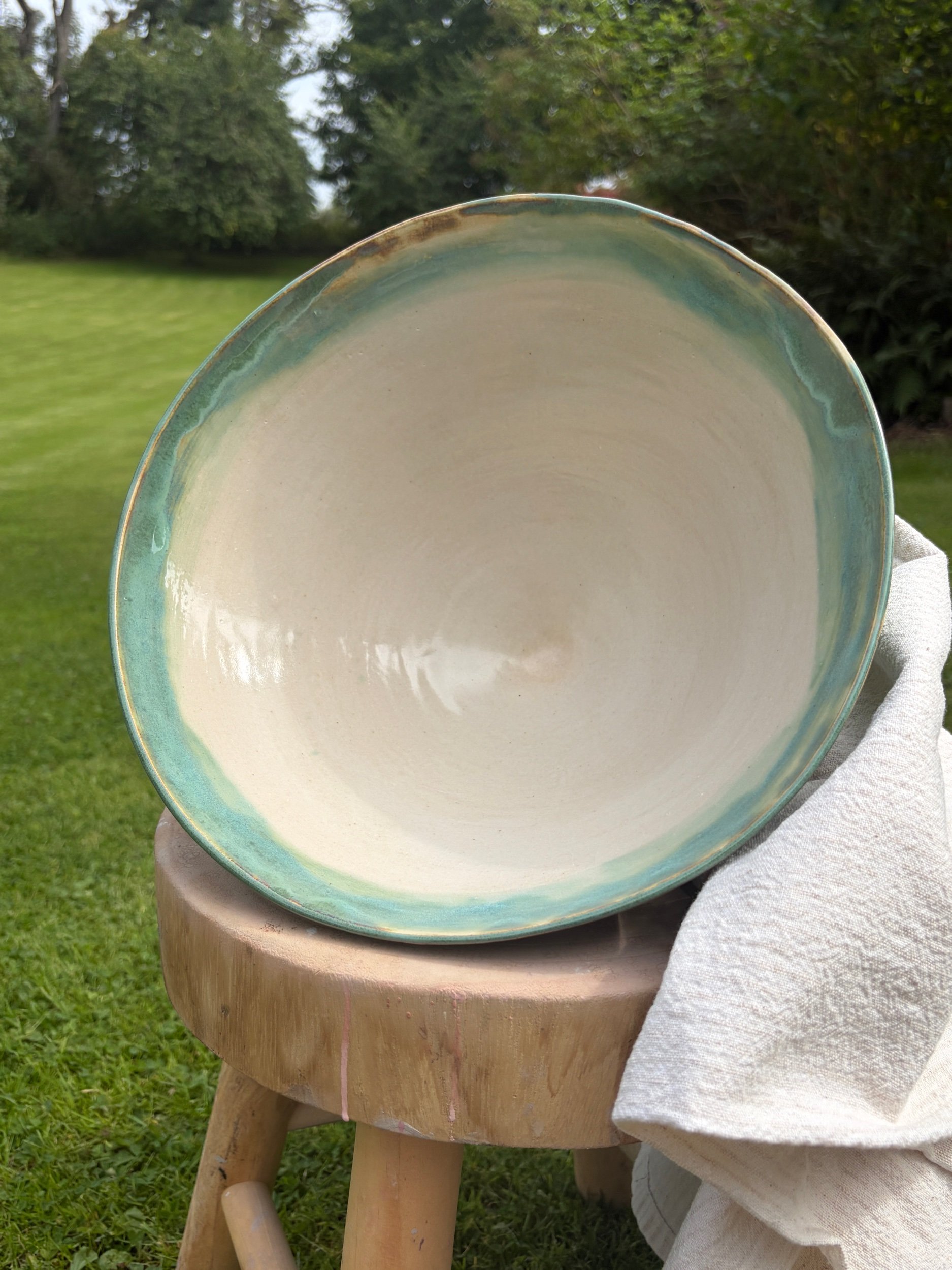 Large V shaped bowl in pistachio glaze with white satin interior glaze on display