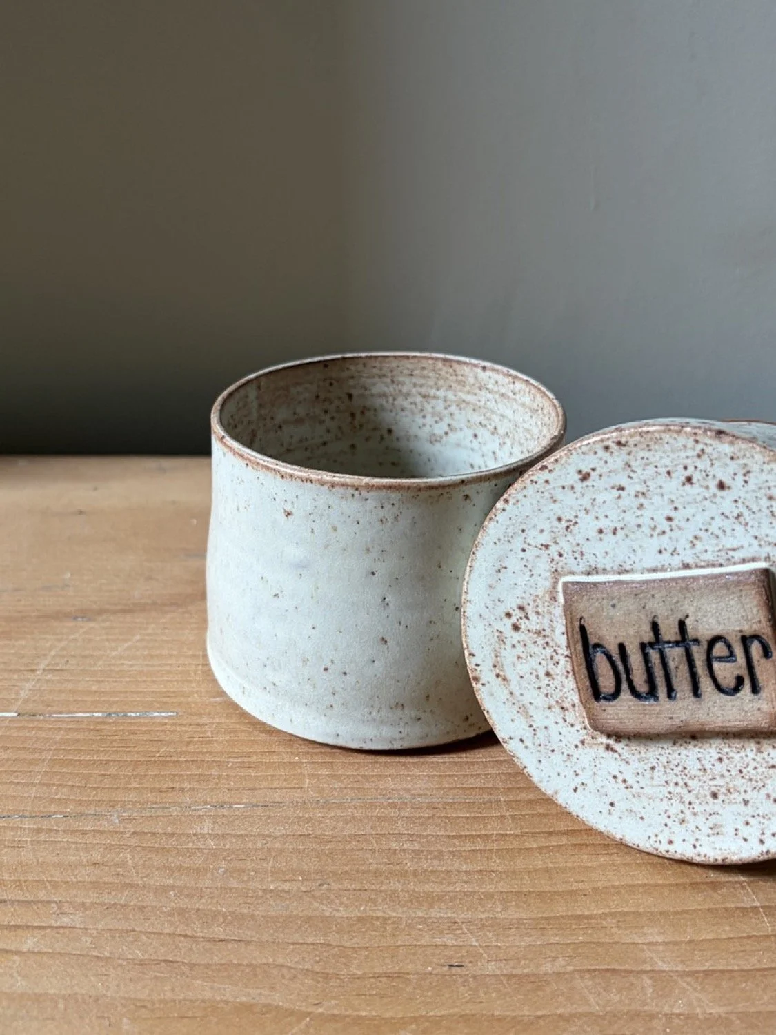 Handcrafted stoneware ceramic french butter press in a vanilla glaze close up image