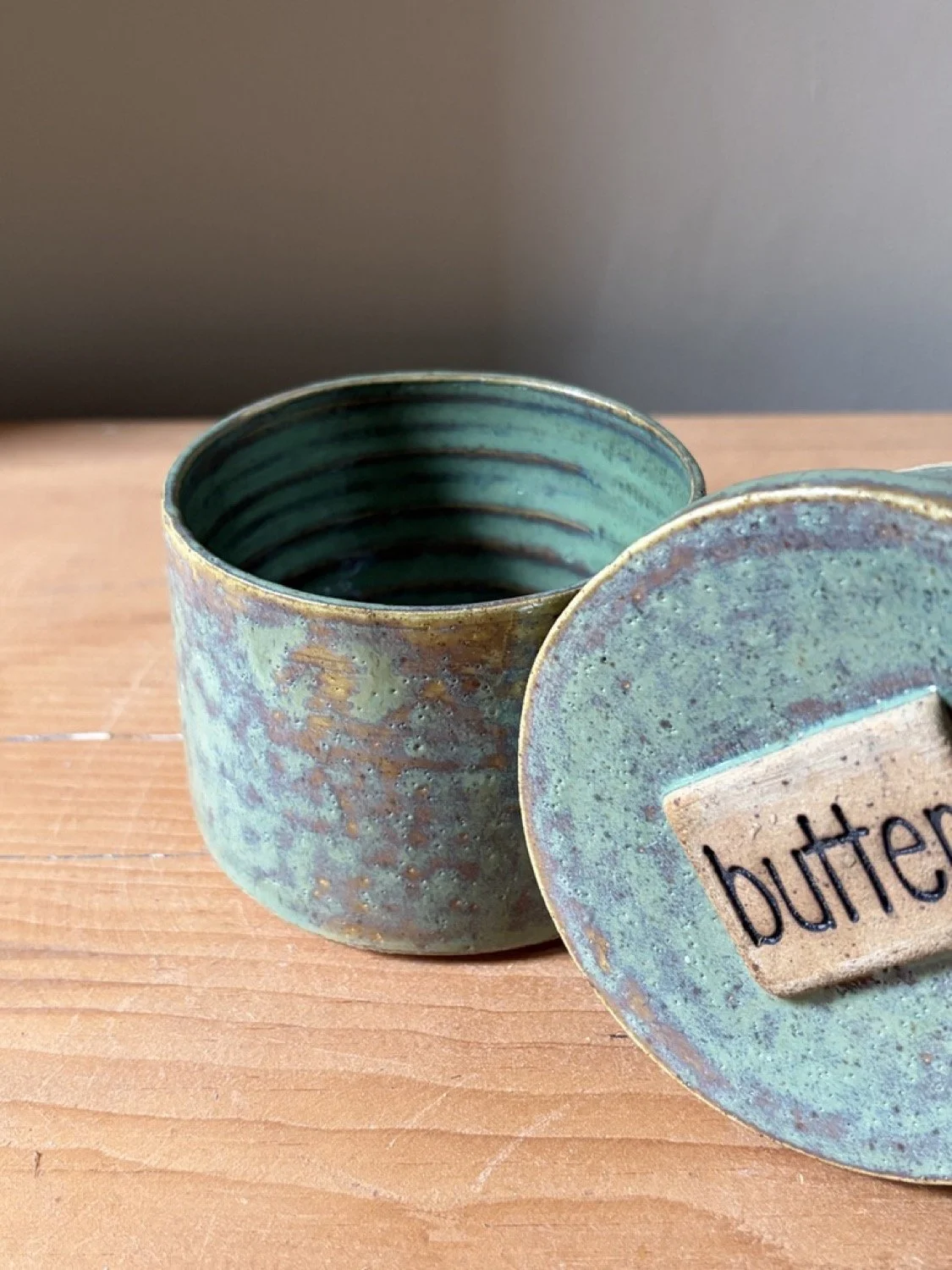 Handmade stoneware pottery french butter press in a pistashio colour glaze image close up