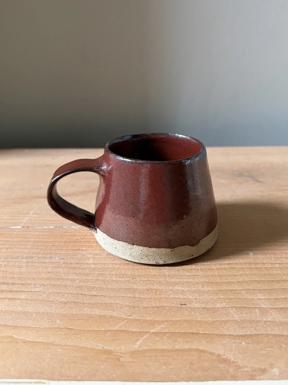 Handmade stoneware small cup in a molten glaze