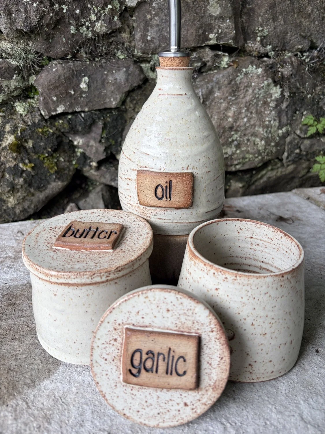 Handcrafted stoneware ceramic french butter press in a vanilla glaze and image shows Garlic Keeper and oil Pourer