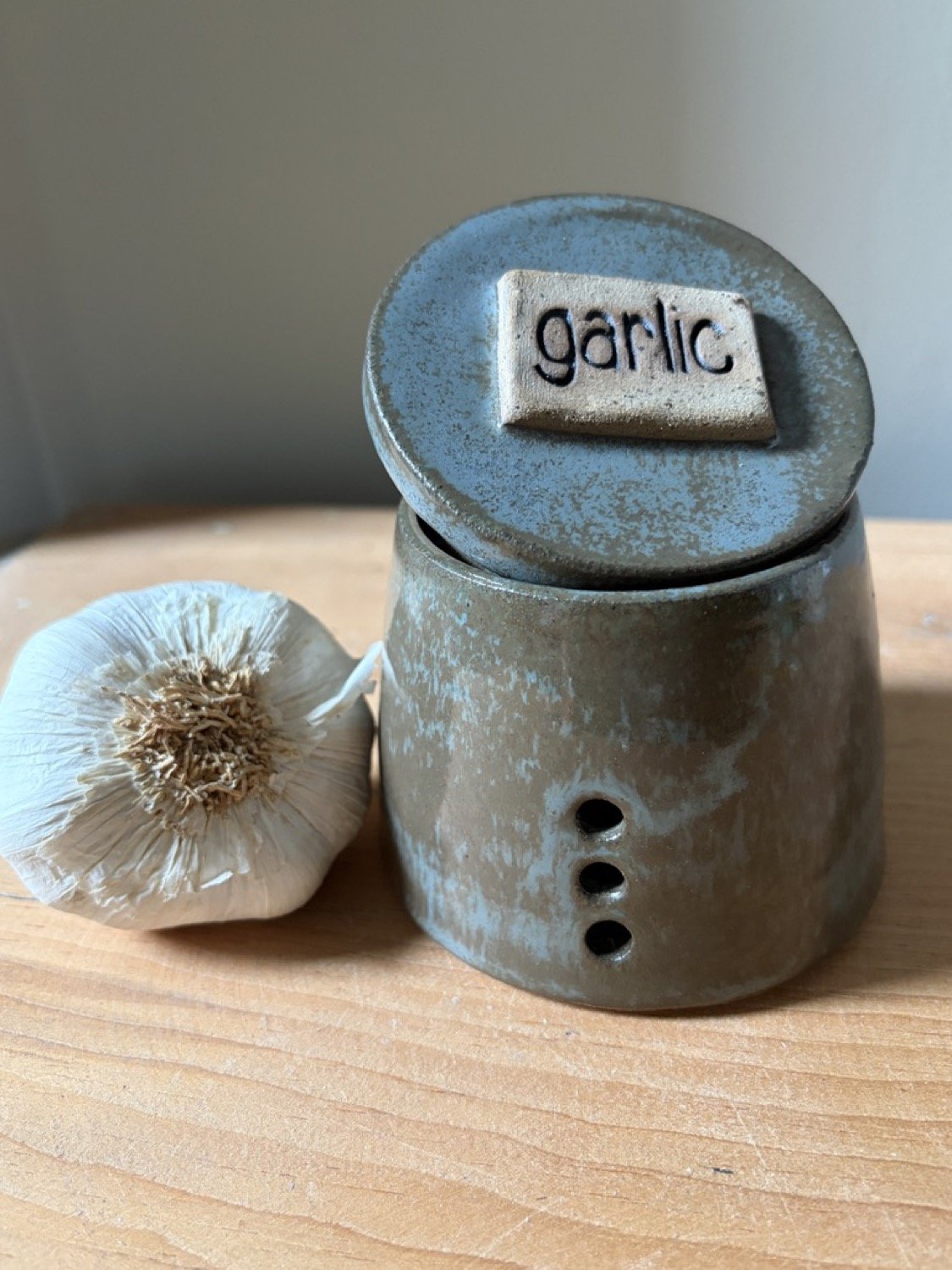 Handmade Stoneware garlic pot in dusty blue glaze and a garlic clove