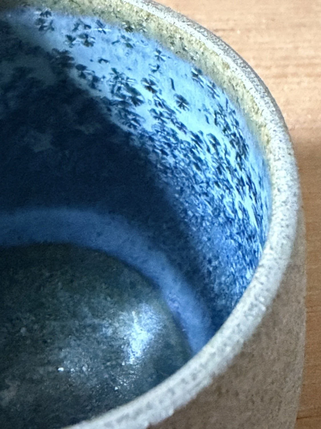 Handcrafted pottery with a handleless cup in glacier glaze close up of the inside