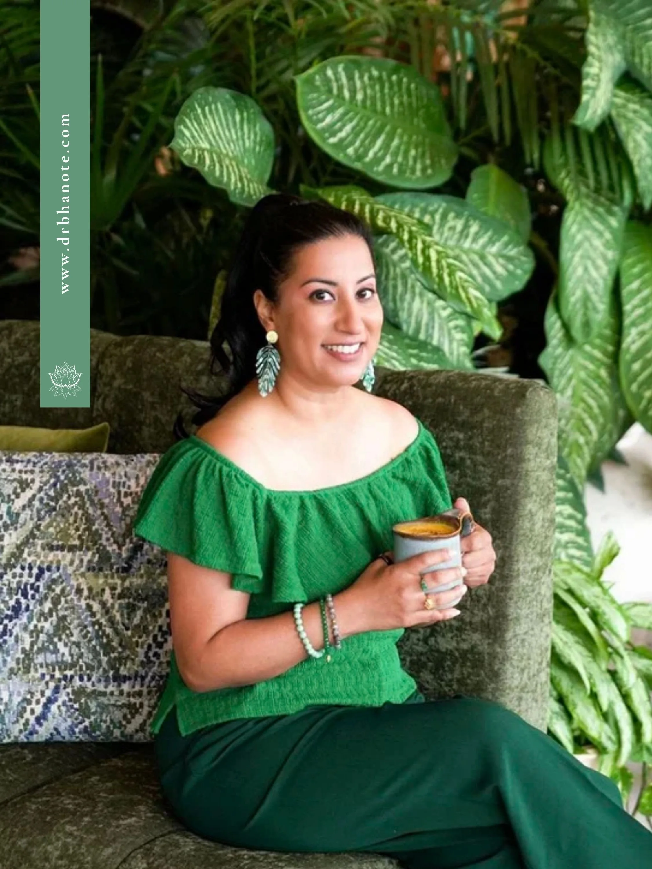 Dr. Monisha Bhanote seated in a lush green setting, holding a warm beverage and smiling, surrounded by tropical plants that reflect her integrative and longevity-focused wellness philosophy.