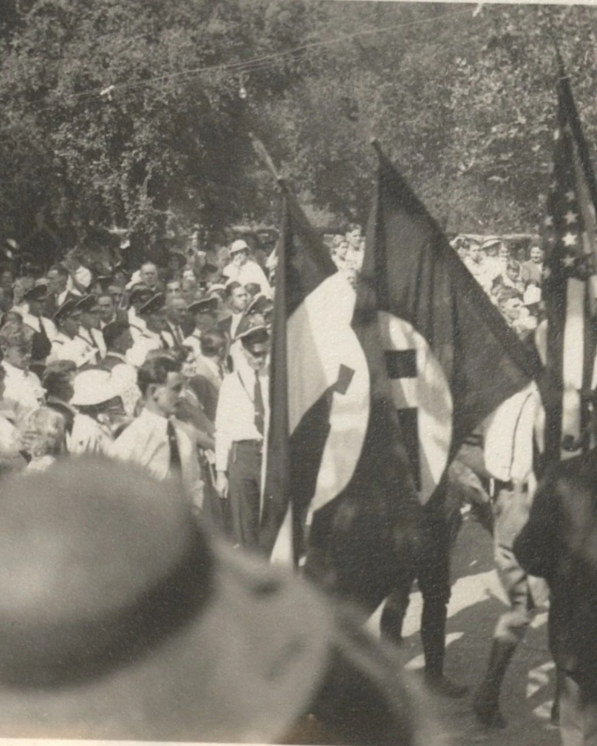 TRAITORS IN TINSELTOWN &middot; La Crescenta Park, Los Angeles, April 1936

A Sunday in the foothills above Los Angeles. Families, women in hats, men in white shirts and caps, and the flags coming in together: the Stars and Stripes, the old Imperial 
