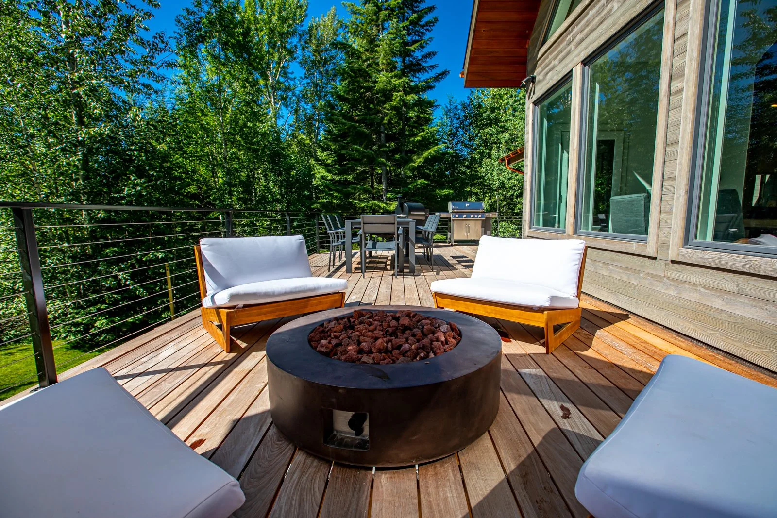 Outdoor fire pit seating on the deck at Back Forty Lodge