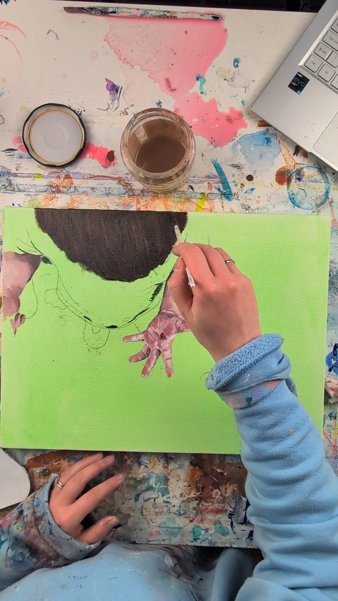 Aerial view showing artist painting portrait using oil and acrylic paints