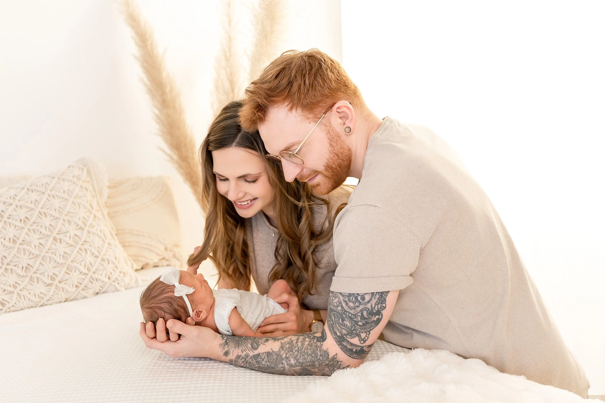 Newbornshooting Saarland, Babyfotos Saarbrücken, Familienfotos Saarland, Newborn Shooting Saarland Ein glückliches Paar hält ein neugeborenes Baby im Schlafzimmer.