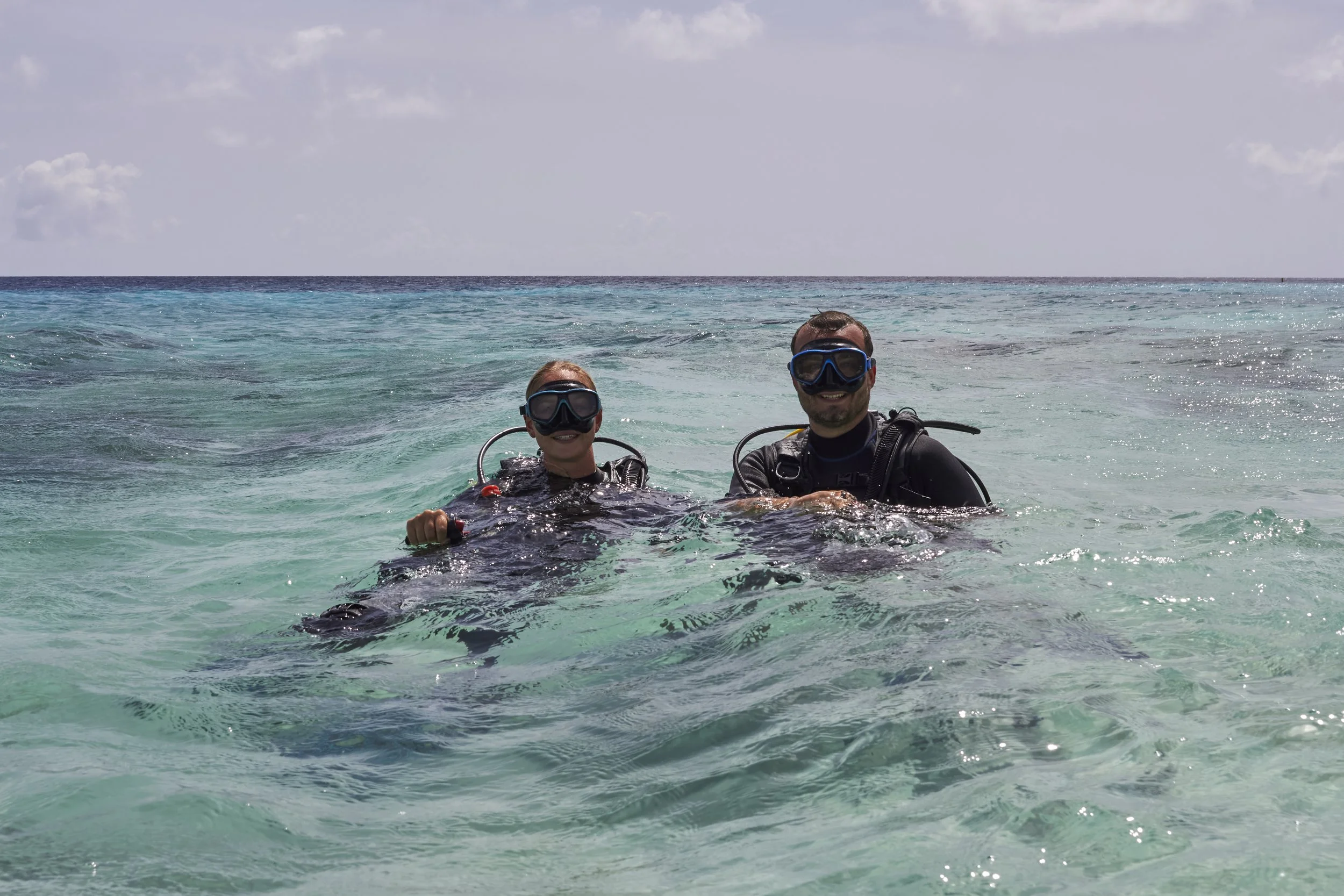 Cruise guests diving together in a small group on Bonaire on the surface