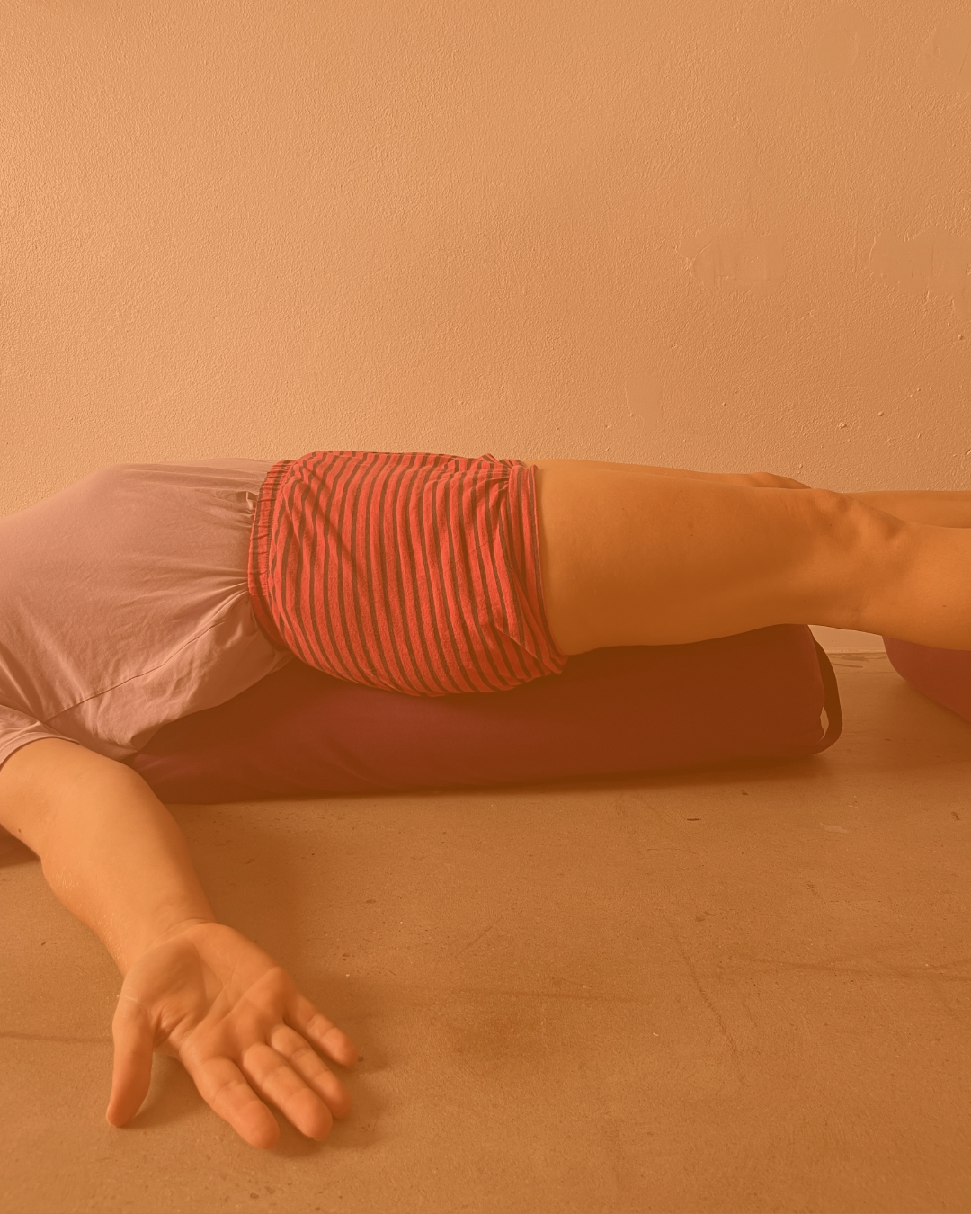 Person performing a yoga pose using wall ropes, with legs elevated and feet pressed together.