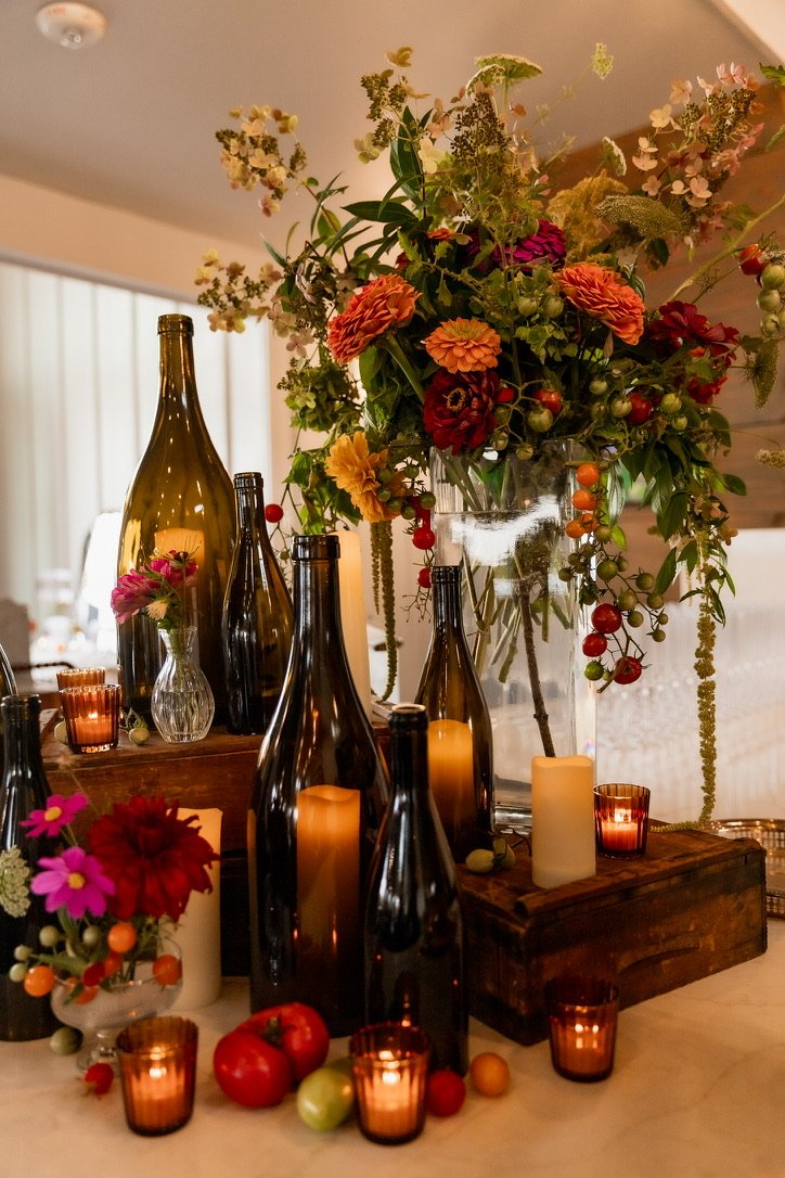 Bar set up for private event with wine bottles and orange and red flowers