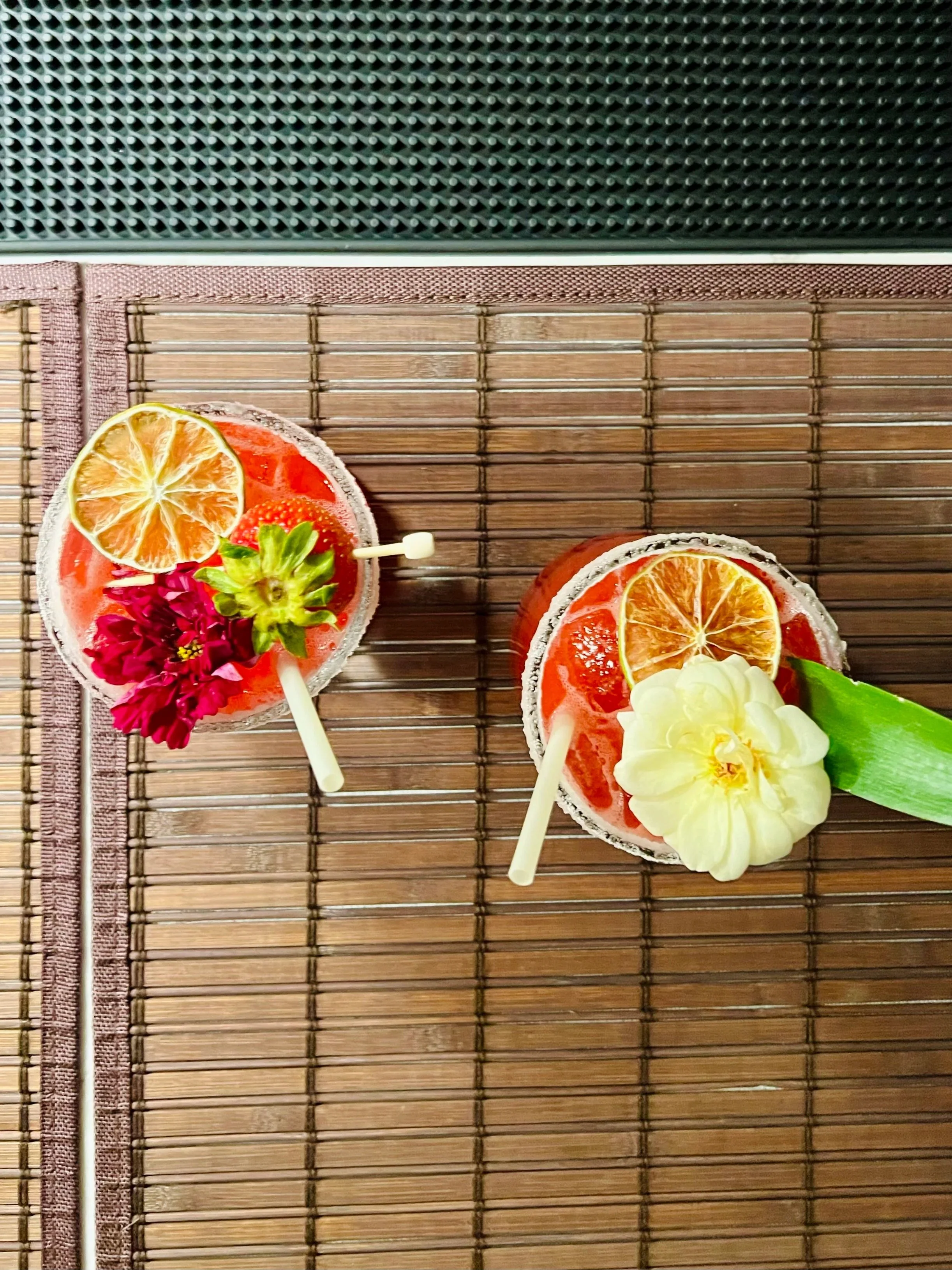Two pink cocktails with floral garnishes prepared by Amaro, a mobile bartending service in Palm Springs and Portland.