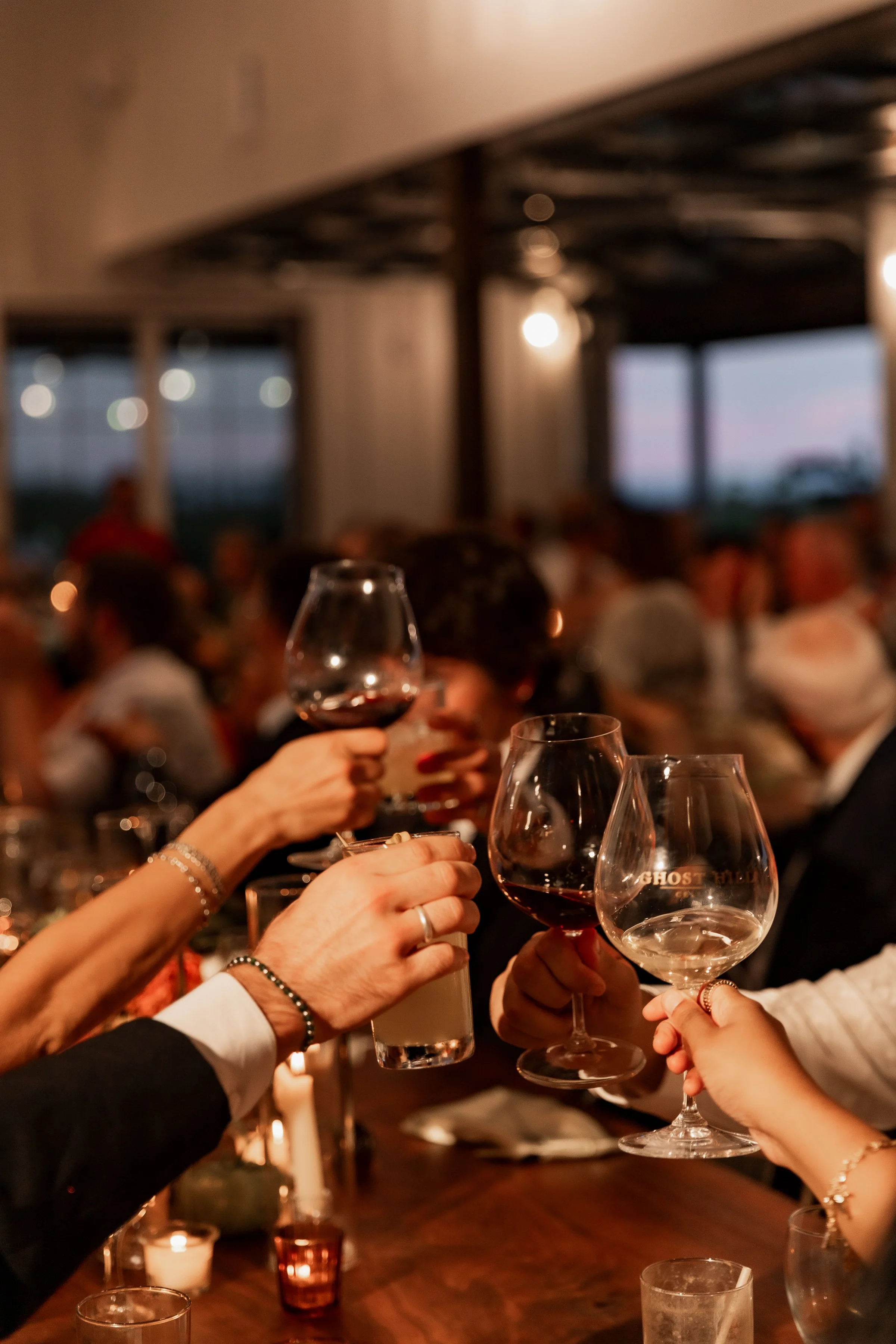 Guests toasting cocktails at a wedding reception catered by a mobile bartending service.