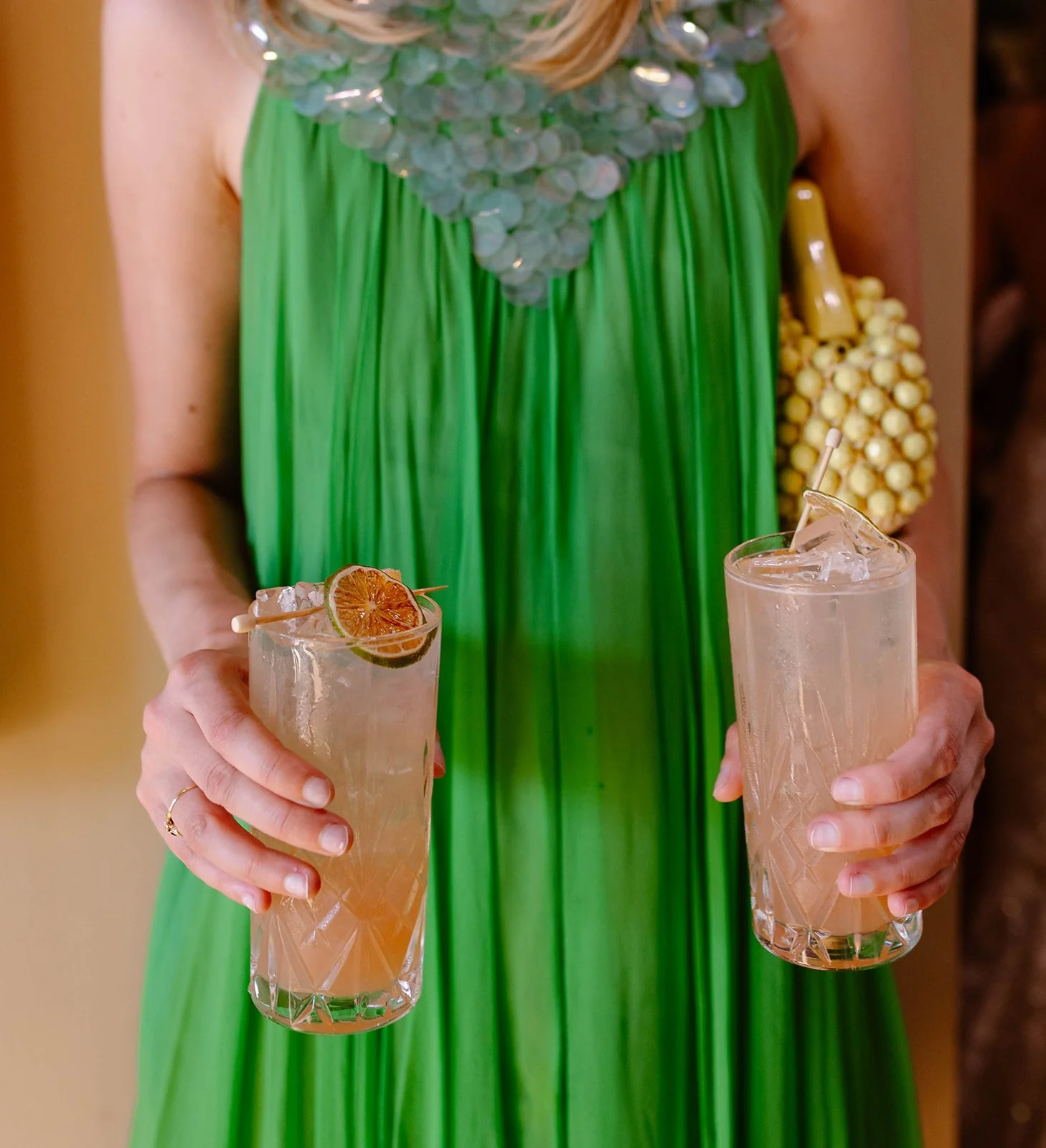 Woman holding two craft cocktails made by bespoke cocktail service.
