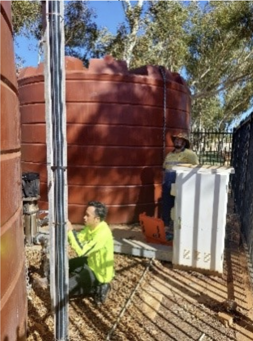 Engineered Efficiency employee conducting maintenance on a water storage tank as part of a pump station
