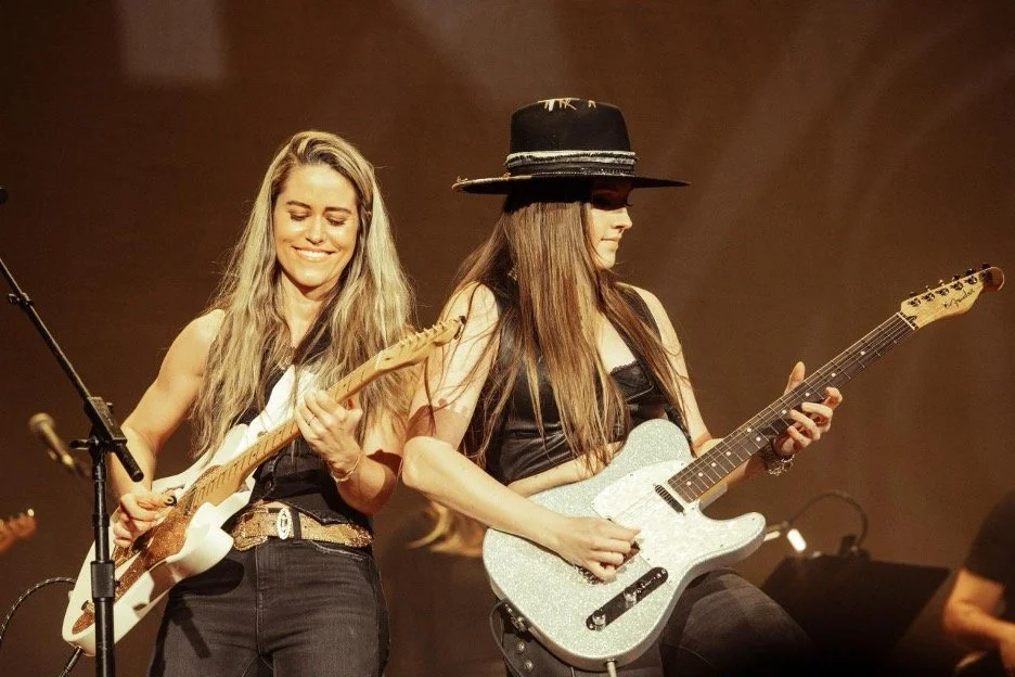 Andrea Benz and Maggie Baugh performing with Fender Telecaster guitars at the Ryman Auditorium
