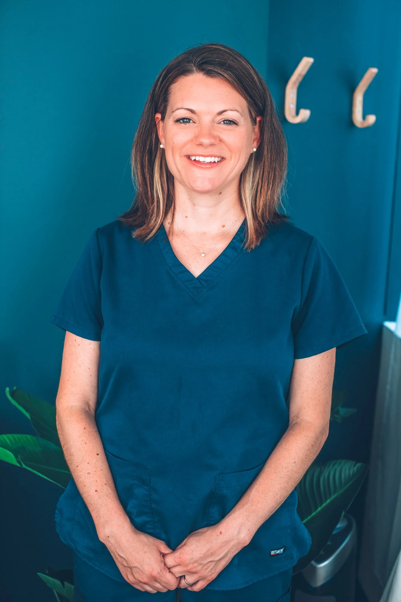 Jennifer McIntosh, licensed acupuncturist and fertility specialist at Soul Sprout Acupuncture, , smiling in a treatment room.