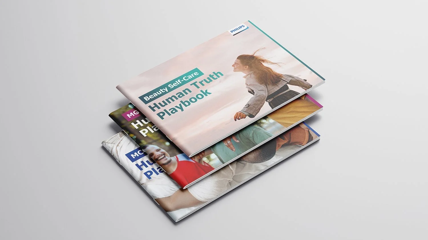 Stack of three booklets, the top one titled "Beauty Self-Care Human Truth Playbook" with an image of a smiling woman with flowing hair outdoors.
