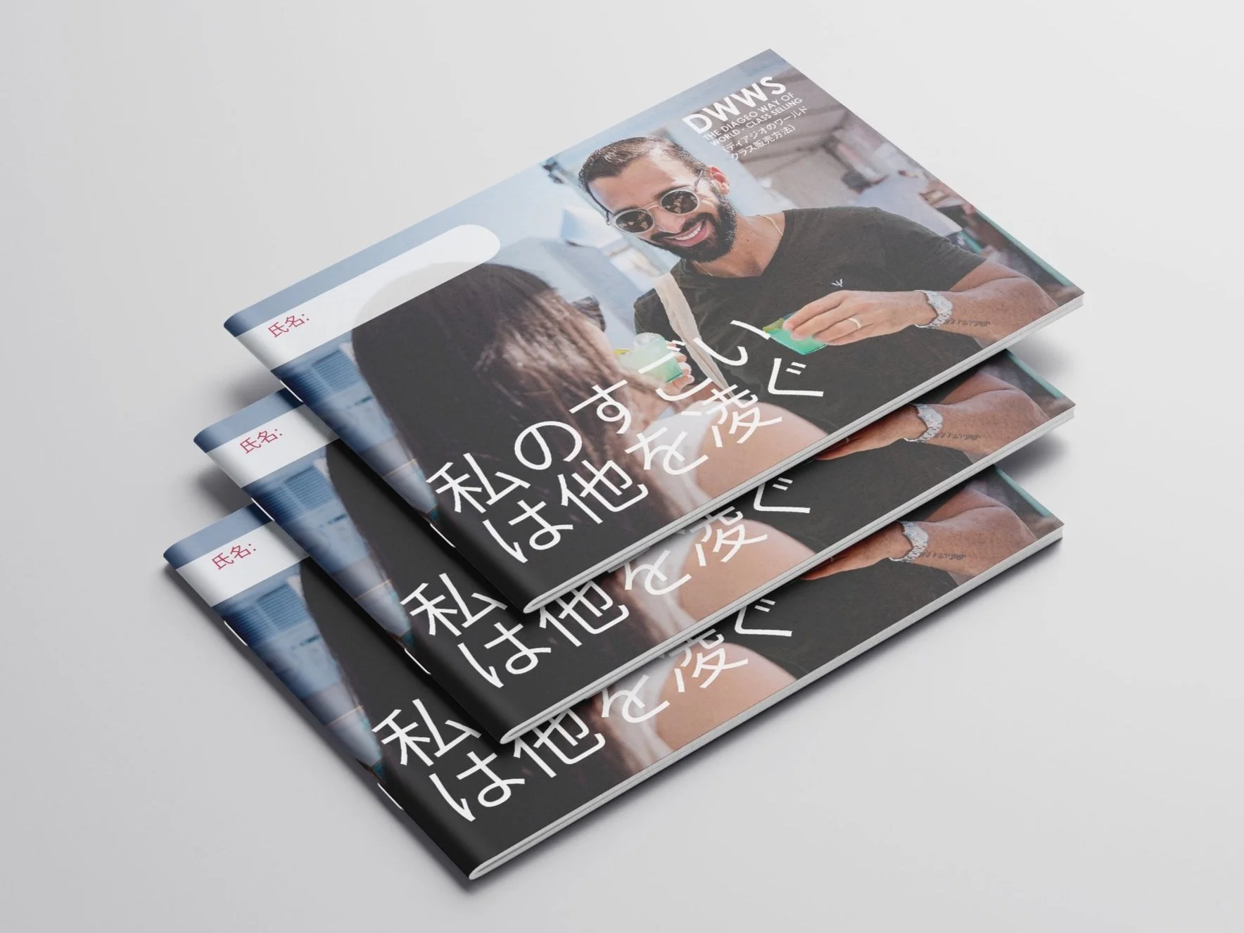 Three identical Japanese language magazines stacked on a white surface, featuring a man with sunglasses and a beard holding a green drink and smiling.