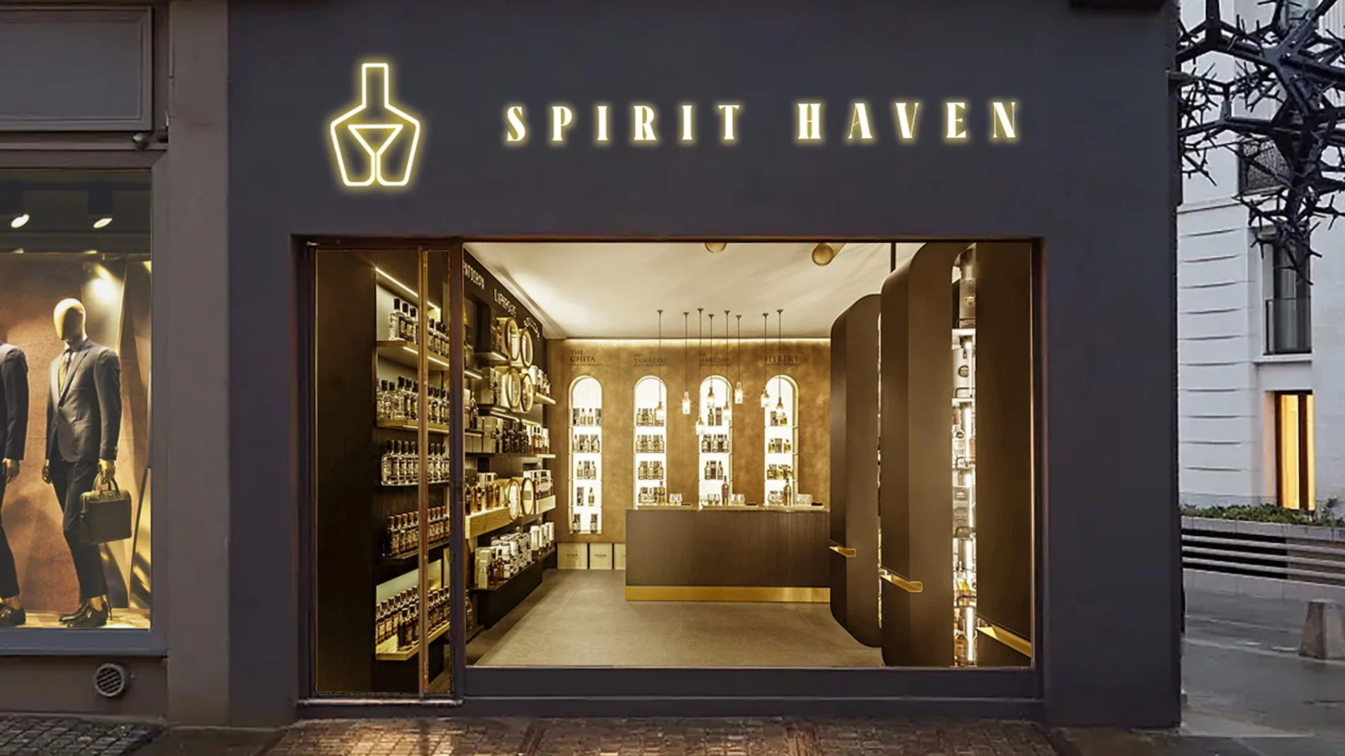 Exterior view of Spirit Haven shop with dark gray facade, illuminated sign, and a window display of mannequins in suits.