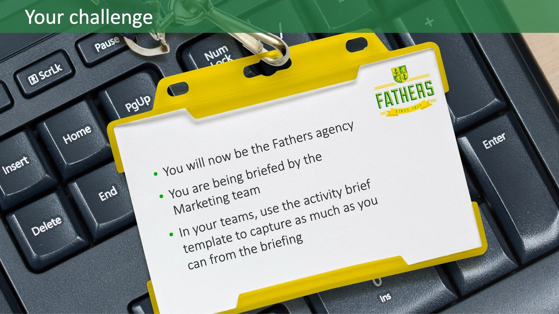 Close-up of a computer keyboard with a yellow briefing card on top. The card has a green and yellow logo with the word 'FATHERS' and text indicating a briefing for new agency responsibilities.