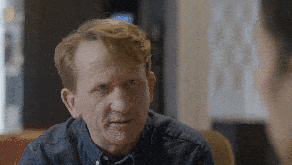 A man with red hair having a conversation with someone outside the frame.