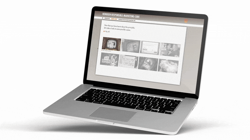 A silver laptop with a black keyboard displaying a webpage titled "Heineken Responsible Marketing Code" on a white background.
