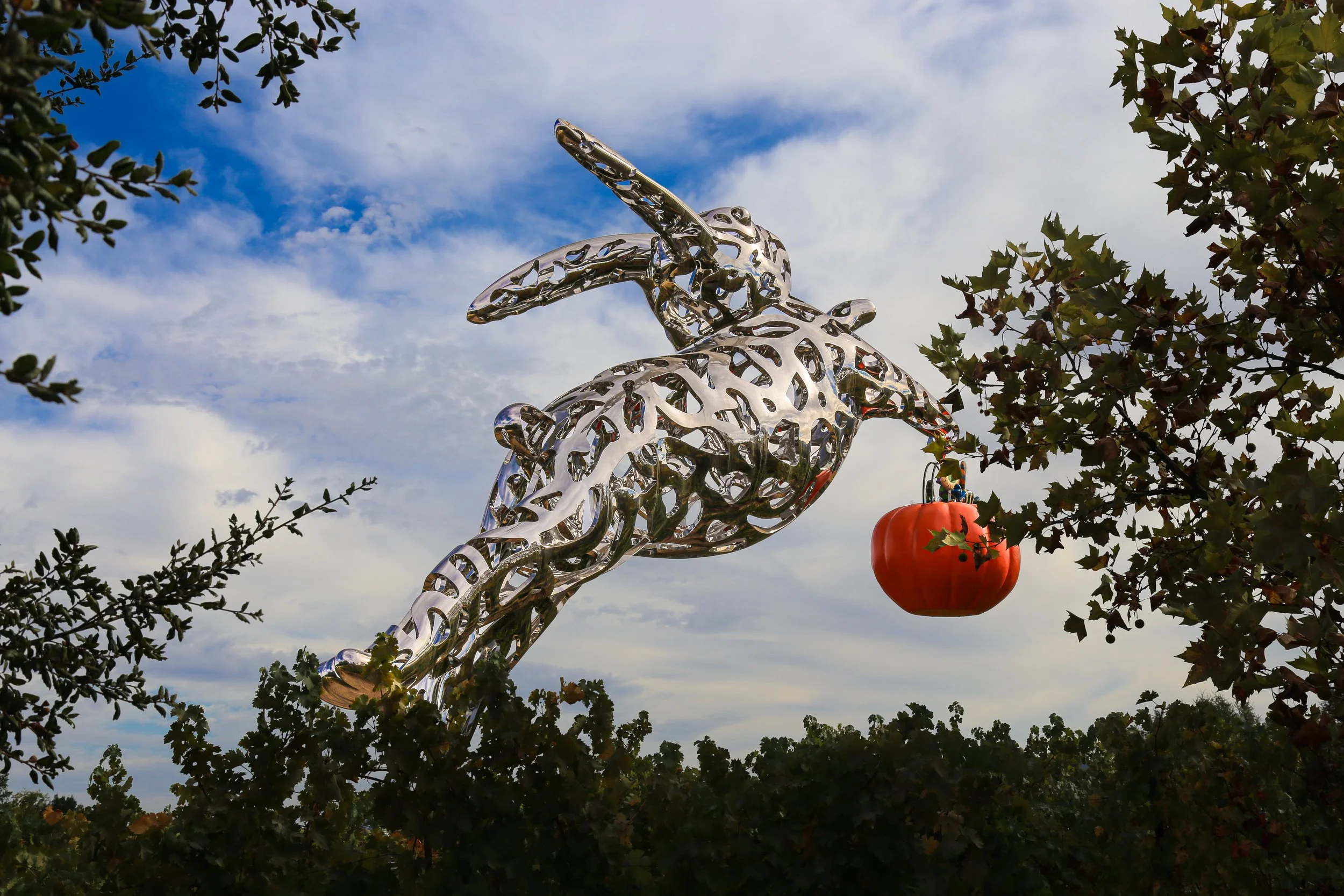 a 35 foot modern sculpture of a stainless steel rabbit leaping through the air