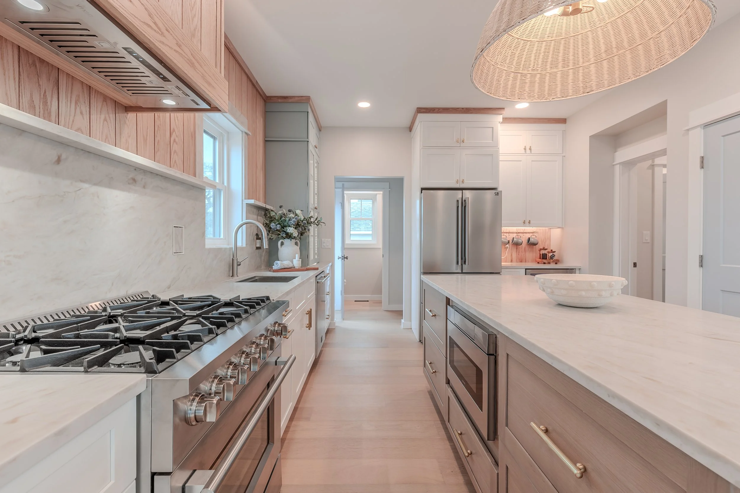 stunning appliances, drink bar, gorgeous marble countertop, and light wood trim