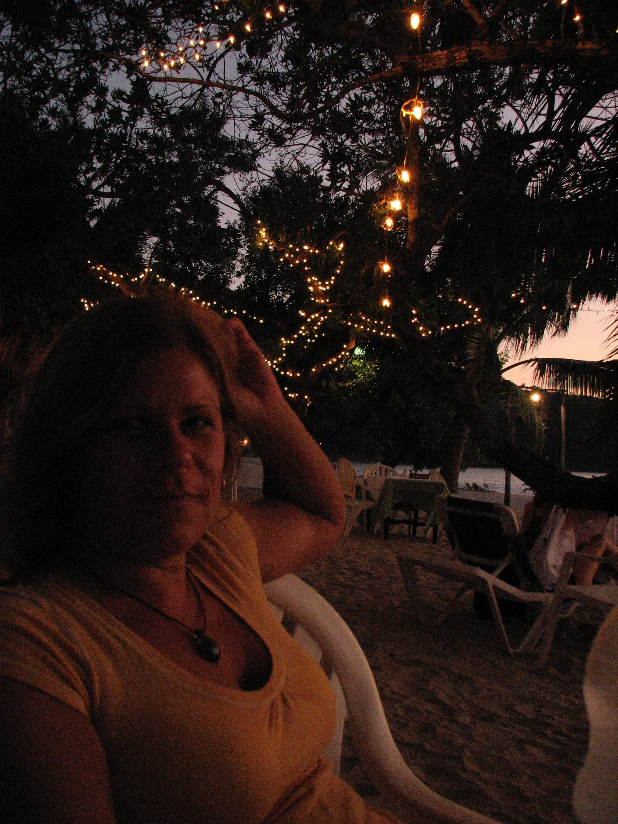 A photo of my friend on the beach in Zihautanejo under the fairy-light trees.