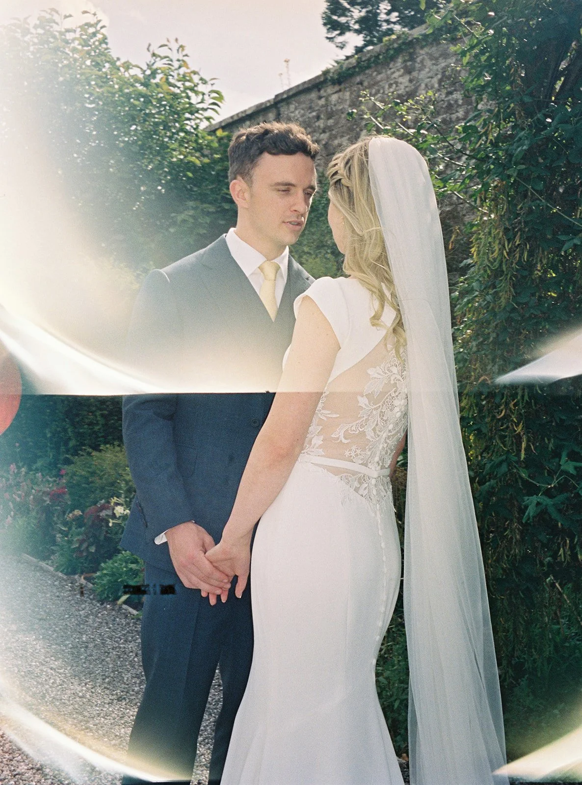 A bride and groom holding hands during their wedding ceremony outdoors.