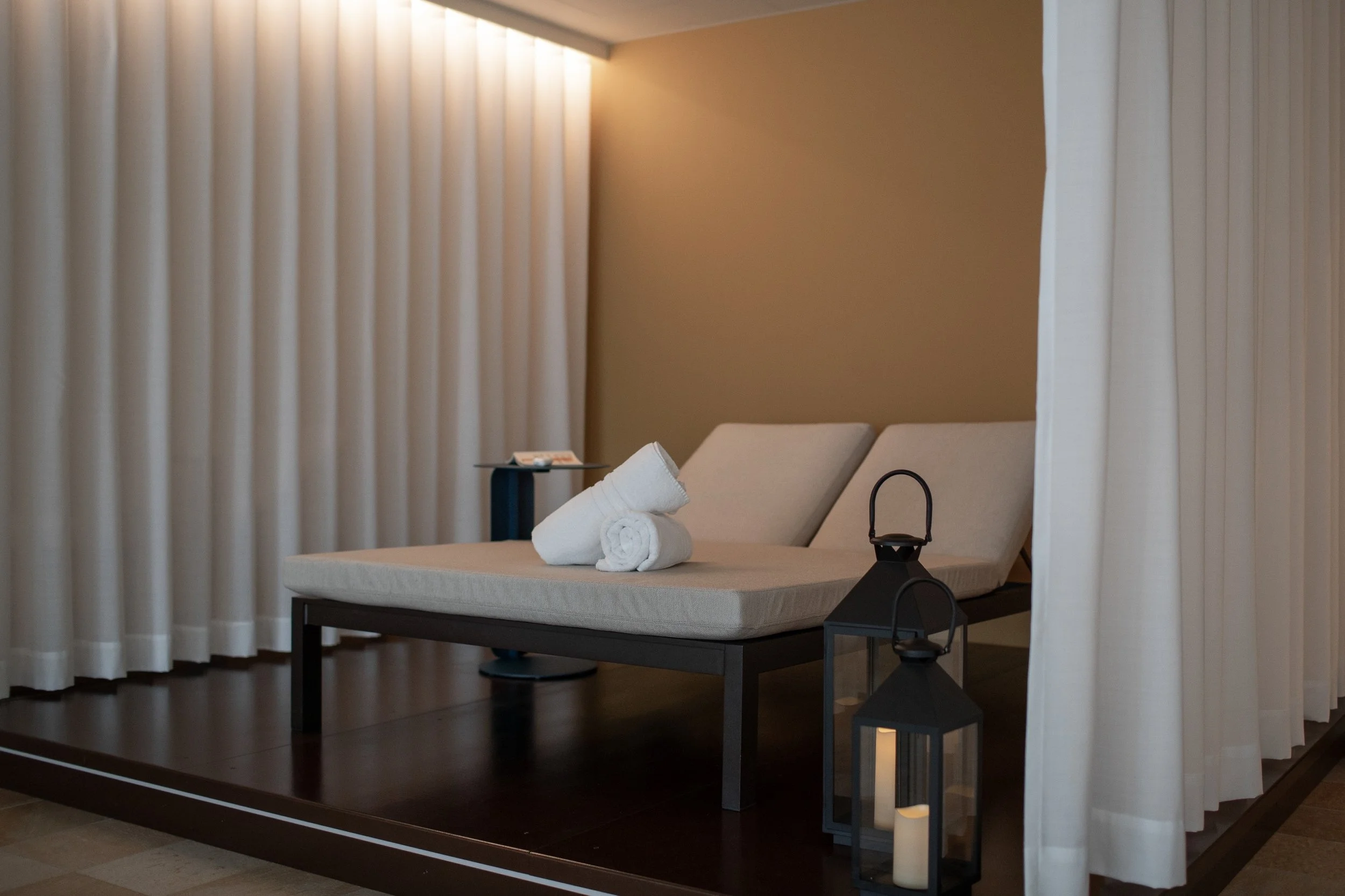 Spa relaxation corner with an adjustable lounger, cushions and warm concealed lighting.