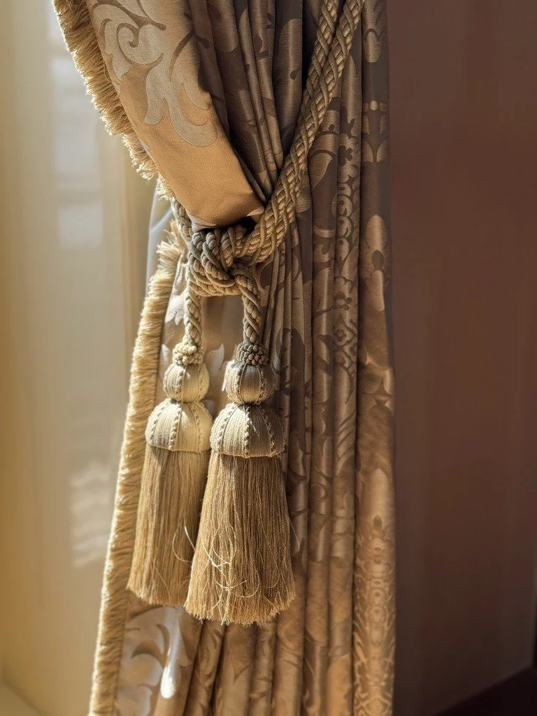 Decorative curtain tieback against richly textured drapery.